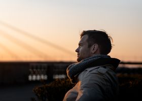 A man enjoys a tranquil moment at sunset outdoors, embodying leisure and tranquility.